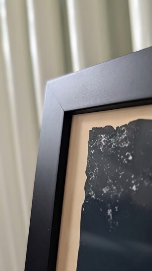 The corner of a black frame and the paper edge