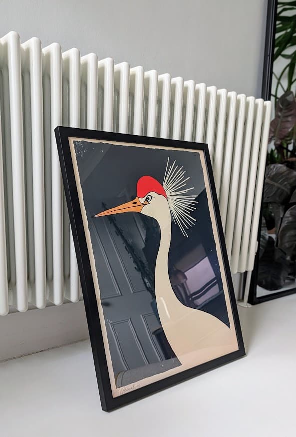 A framed print leaning against a wall at home